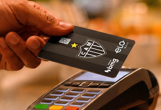 Cartão de crédito sem taxas da conta digital do Galo Bmg sendo inserido em uma máquina de pagamento
