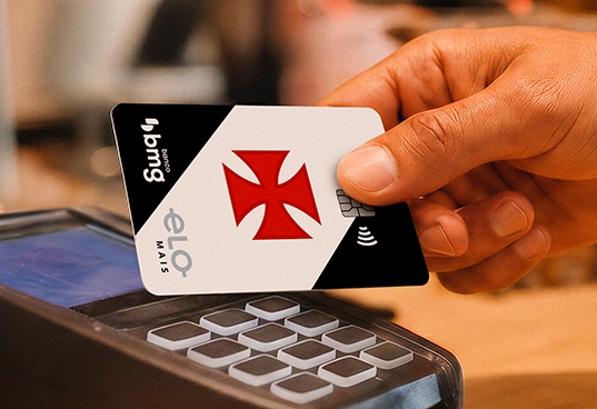 Cartão de crédito sem taxas da conta digital do Vasco Bmg sendo inserido em uma máquina de pagamento