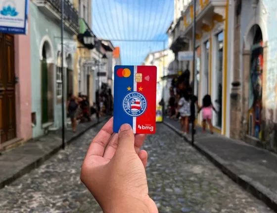 Ilustração com uma mulher de camisa de cor laranja, acessando open Finance pelo celular