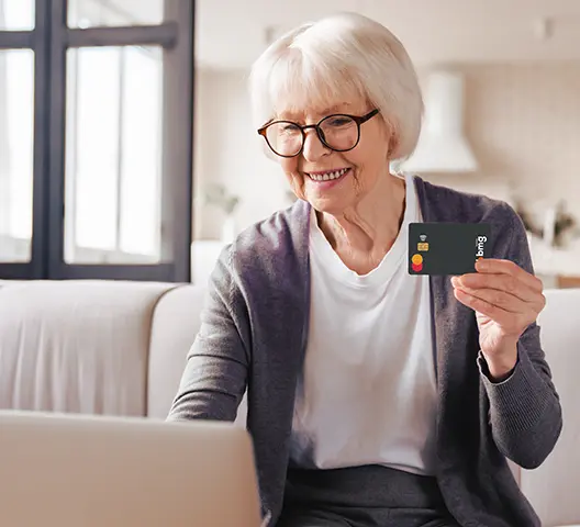 Imagem contém uma senhora de ocúlos, blusa azul claro e sorrindo.