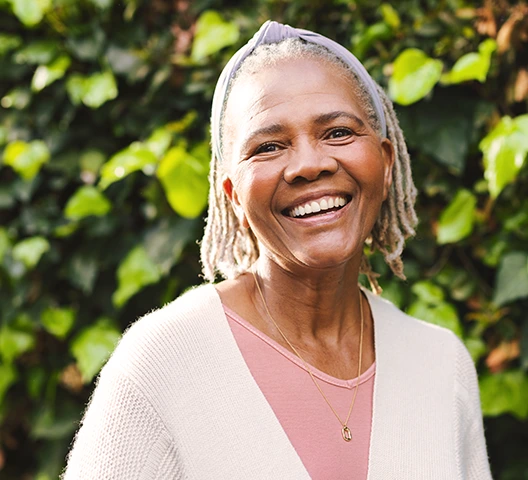 Homem sorrindo com blusa social quadriculada branco e azul de cabelos brancos.