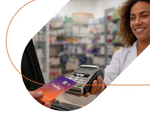 Imagem de uma farmacêutica recebendo o cartão para efetuar o pagamento do cliente